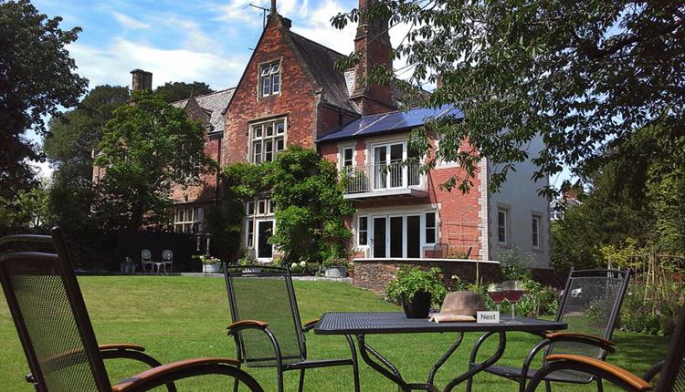 Front view of The Old Vicarage looking across the garden