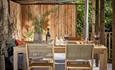 A rustic wooden table with four chairs arranged around it, set in a cozy dining area.