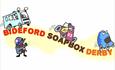 Cartoon illustration of colourful soapbox cars racing down a yellow path, with a cheering figure. Text reads "Bideford Soapbox Derby," conveying excit