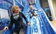 mother and toddler on a blue slide in soft play area @ The Milky Way Adventure Park