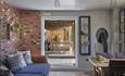 A stylish living room with a rustic brick wall and a plush couch, designed for relaxation and comfort.