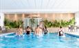5 people in a swimming pool following an instructor