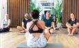 5 people participating in a yoga session following an instructor