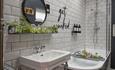 A bathroom featuring a bathtub, sink, and mirror, showcasing a clean and modern design.